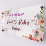 Floral Vineet and Ruby couple name plate with house number angled on a white background