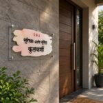 Hindi name plate for home mounted on a stone wall beside a wooden main door - Kulkarni Marathi watercolour design