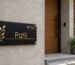 Modern minimalist name plate design - matte black acrylic plate on a contemporary home entrance