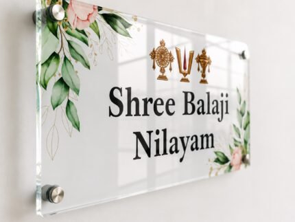 Angled view of transparent Shree Balaji Nilayam acrylic name plate showing glossy finish and standoff mounts