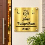 Customised name plate for home in golden brushed stainless steel, 12 by 12 inches, installed entrance view