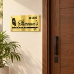 Metal name plate for home in golden brushed stainless steel, 6 by 12 inches, installed entrance view