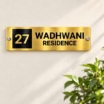 Name plate for office in golden brushed stainless steel, 4 by 12 inches, installed entrance view