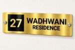 Name plate for office in golden brushed stainless steel, 4 by 12 inches, wall-mounted view