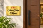 Steel name plate for home in golden brushed stainless steel, 8 by 12 inches, installed entrance view