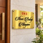 Steel name plate for home in golden brushed stainless steel, 8 by 12 inches, installed entrance view